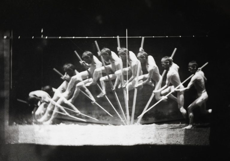 A black and white photo of multiple people pole vaulting