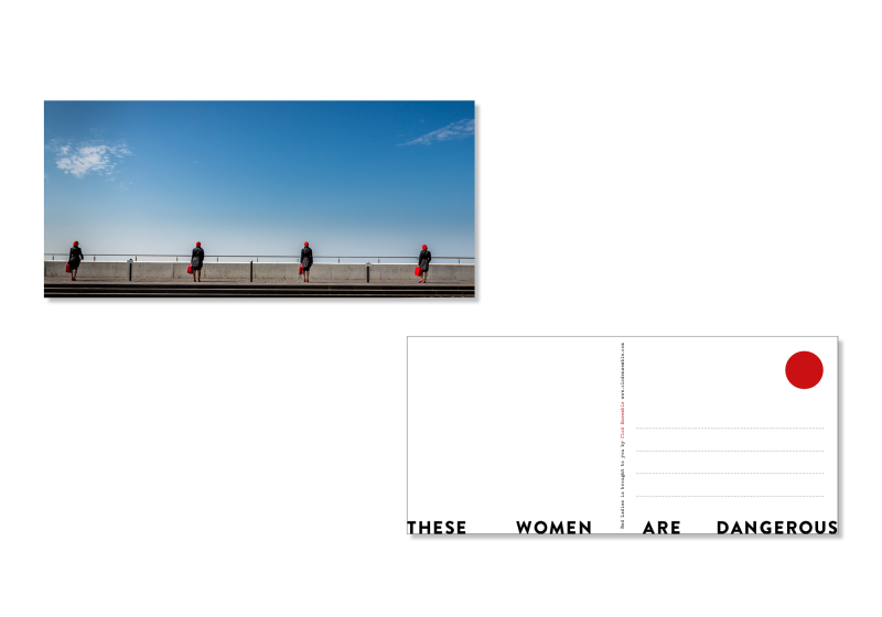 Postcard from Clod Ensemble's show Red ladies showing front and back. The front is printed with a photo of the Red Ladies in Margate with their backs against the camera against a blue sky. The back reads "These women are dangerous' and leaves space for a message and a stamp.